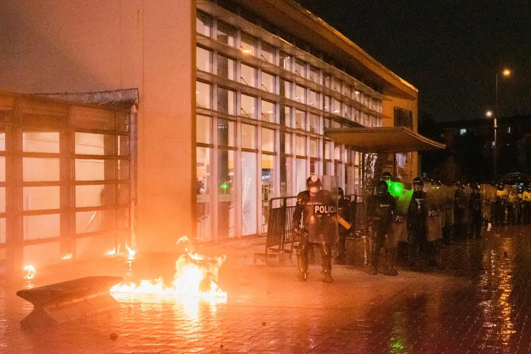 Colombia's riot police stands back as a molotov bomb explodes near their feet in a new day of anti-government protests against President Ivan Duque's health and tax reforms and police brutality that leaves at least 70 dead in the past month of protests. Photo: Daniel Romero/dpa.