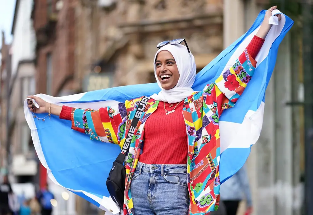 17 June 2021, United Kingdom, Glasgow: A Scotland fan cheers at the Central station in Glasgow as they prepare to travel to London ahead of Friday's UEFA EURO 2020 Group D match between England and Scotland at Wembley Stadium. Photo: Jane Barlow/PA Wire/dpa