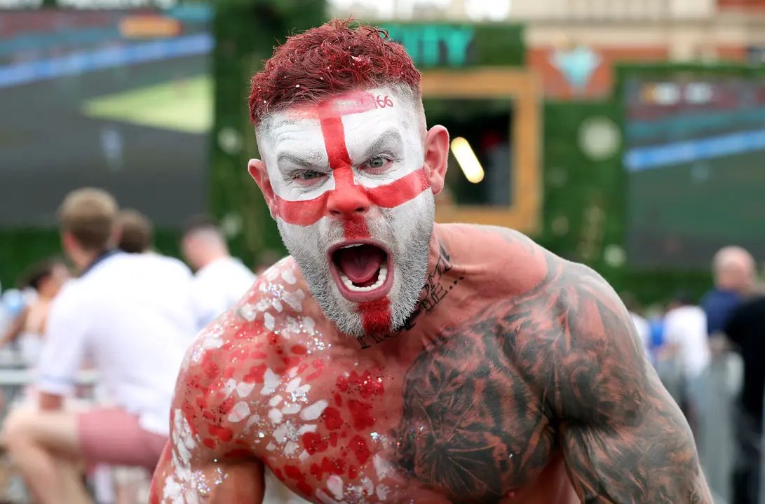 13 June 2021, United Kingdom, Manchester: An England fan with body paint cheers at the fan zone of Trafford Park while watching the UEFA EURO 2020 Group D soccer match between England and Croatia at Wembley Stadium. Photo: Bradley Collyer/PA Wire/dpa.