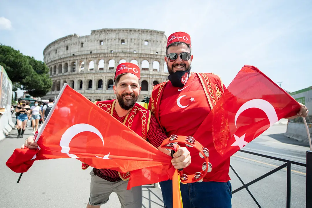 11 June 2021, Italy, Rome: Turkish fans cheer in front of the Colosseum in Rome with their national flags ahead of the UEFA EURO 2020 Group A soccer match between Italy and Turkey, at the Olympic Stadium . Photo: Matthias Balk/dpa.