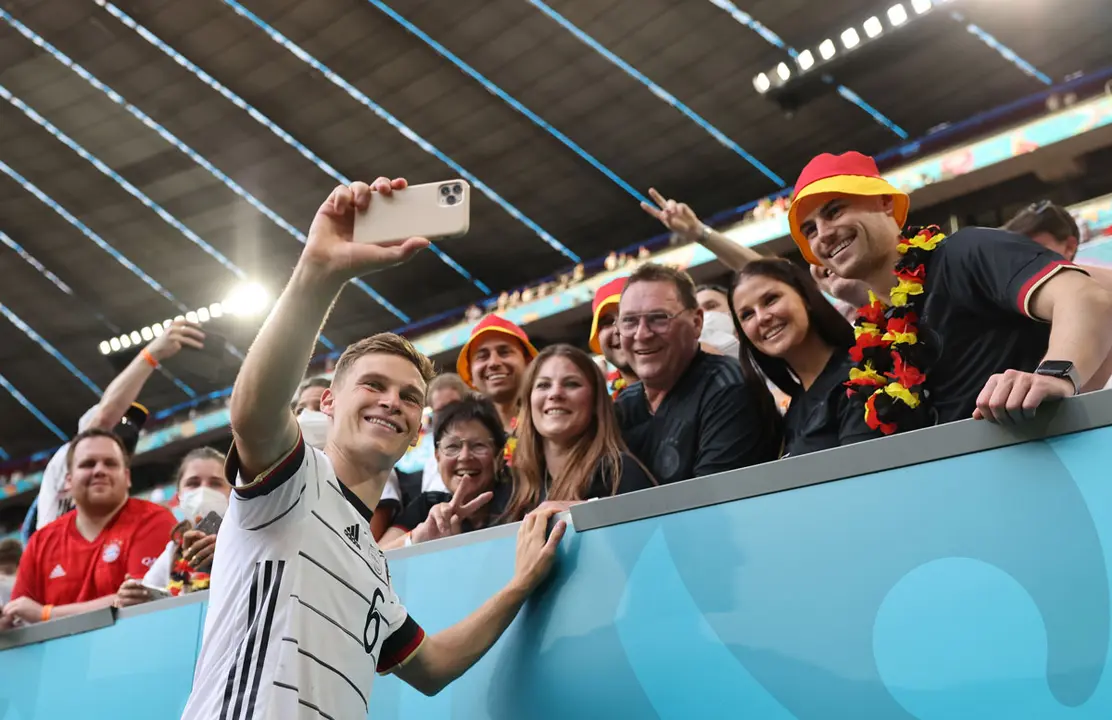 19 June 2021, Bavaria, Munich: Germany's Joshua Kimmich takes a selfie with fans after the UEFA EURO 2020 Group F soccer match between Portugal and Germany at the Allianz Arena. Photo: Christian Charisius/dpa