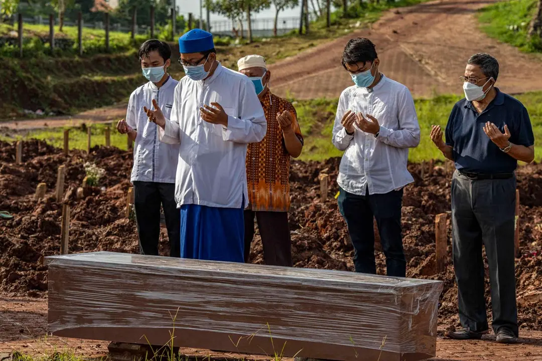 21 June 2021, Indonesia, Tangerang Selatan: People pray during the funeral of a COVID-19 victim at the Jombang Covid-19 Public Cemetery (TPU). Photo: Donal Husni/ZUMA Wire/dpa
