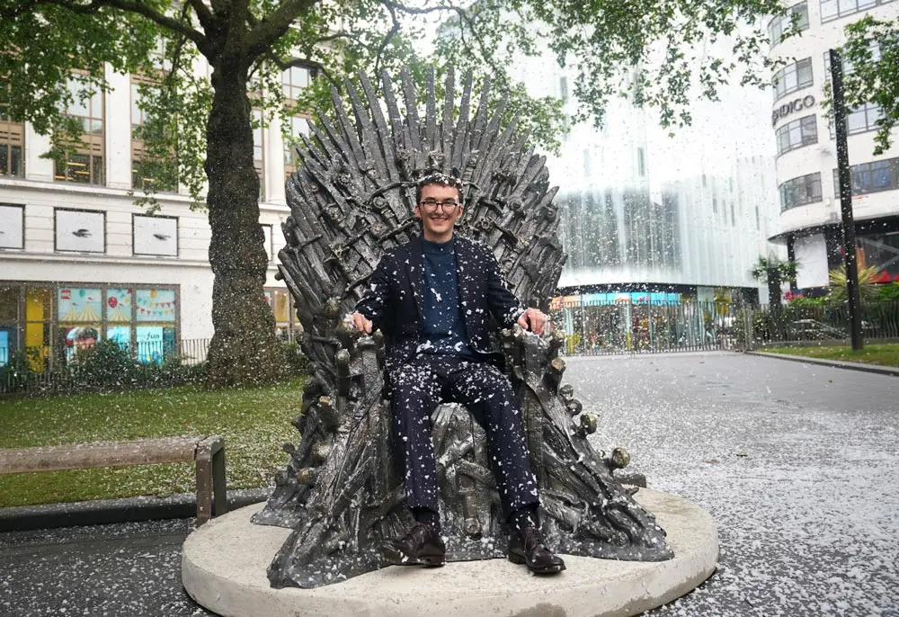 22 June 2021, United Kingdom, London: British actor Isaac Hempstead Wright sits on the statue of the Iron Throne from the Game of Thrones television series, after its unveiling in Leicester Square, central London, to mark the show's 10th anniversary. Photo: Yui Mok/PA Wire/dpa