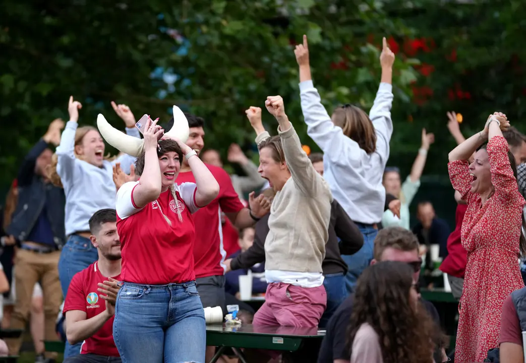 26 June 2021, United Kingdom, London: Denmark Fans cheer at Potters Fields Park, as they watch the UEFA EURO 2020 round of 16 soccer match between Wales and Denmark. Photo: John Walton/PA Wire/dpa