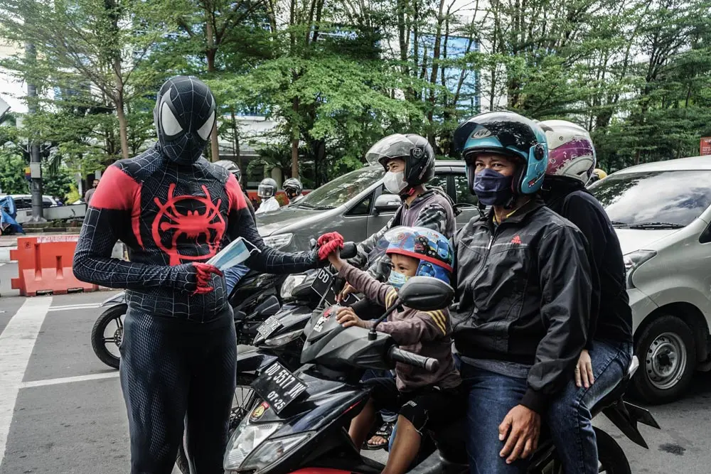 28 June 2021, Indonesia, Makassar: An Indonesian police officer wearing a Spiderman costume takes part in a campaign distributing masks to the public to prevent the further spread of COVID-19. Photo: Herwin Bahar/ZUMA Wire/dpa