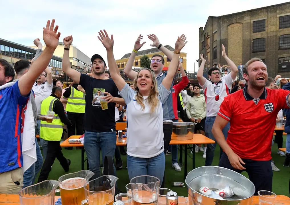 03 July 2021, United Kingdom, London: Fans cheer at the Vinegar yard as they watch the UEFA EURO 2020 Quarter-Final soccer match between Ukraine and England during a public screening for the match. Photo: Ashley Western/PA Wire/dpa
