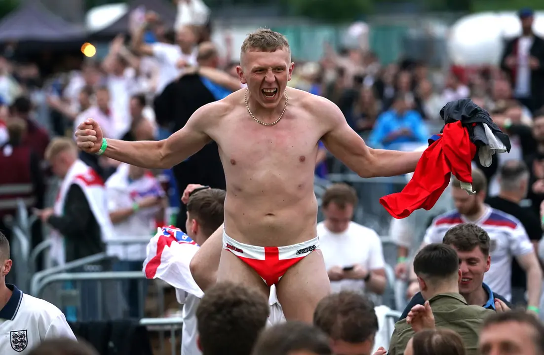 03 July 2021, United Kingdom, Manchester: Fans celebrate Harry Kane's third goal as they watch the UEFA EURO 2020 Quarter-Final soccer match between Ukraine and England during a public screening for the match. Photo: Martin Rickett/PA Wire/dpa.
