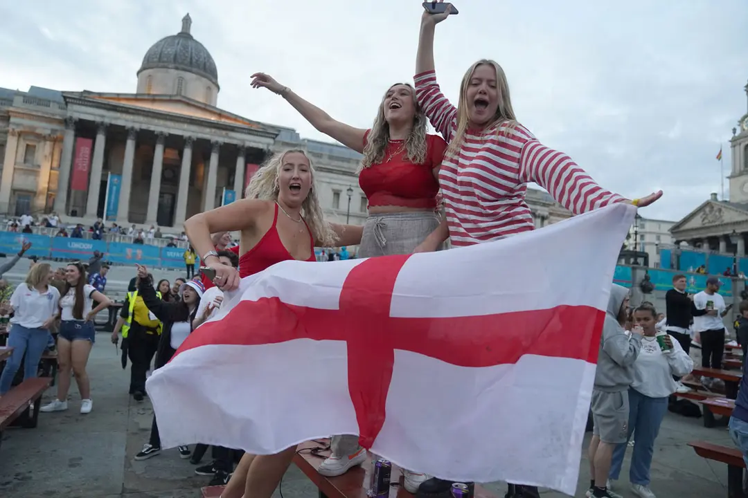 03 July 2021, United Kingdom, London: Fans in Trafalgar Square celebrate Harry Kane's third goal while watching the UEFA EURO 2020 Quarter-Final soccer match between Ukraine and England during a public screening for the match. Photo: Victoria Jones/PA Wire/dpa