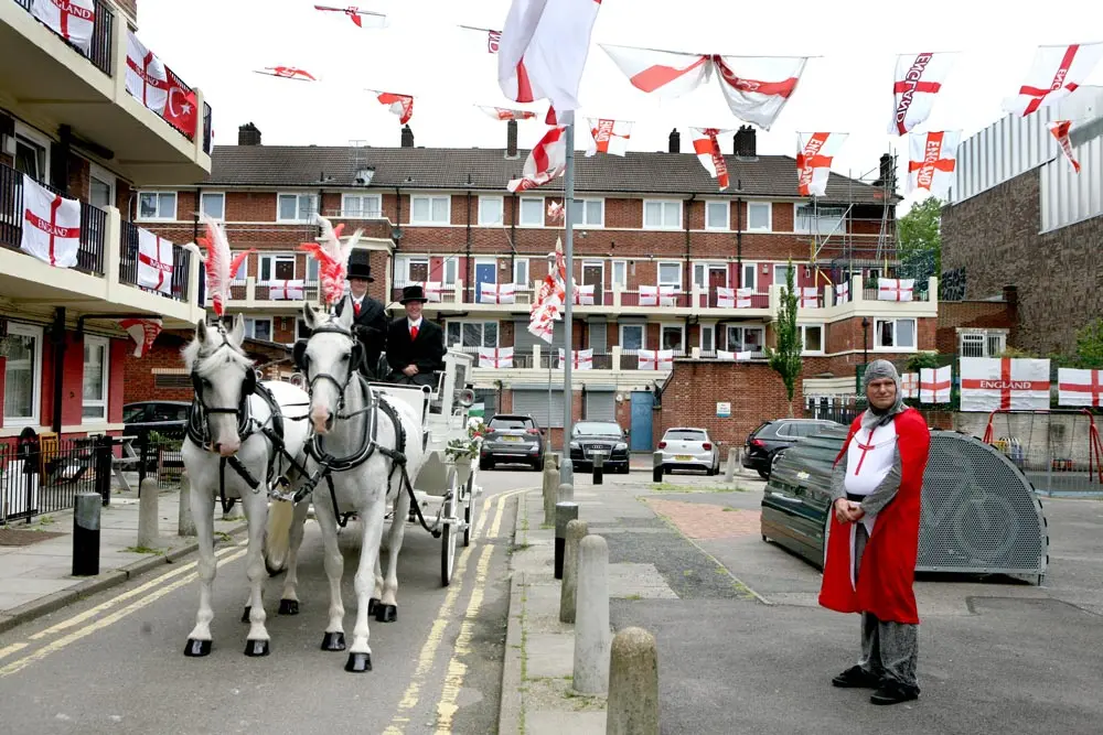 07 July 2021, United Kingdom, London: Alan Putman (R), in costume, stands next to a horse drawn carriage, on the Kirby Estate in Bermondsey, south London, where residents are showing their support for England ahead of the UEFA Euro 2020 semi final soccer match between England and Denmark. Photo: Luciana Guerra/PA Wire/dpa