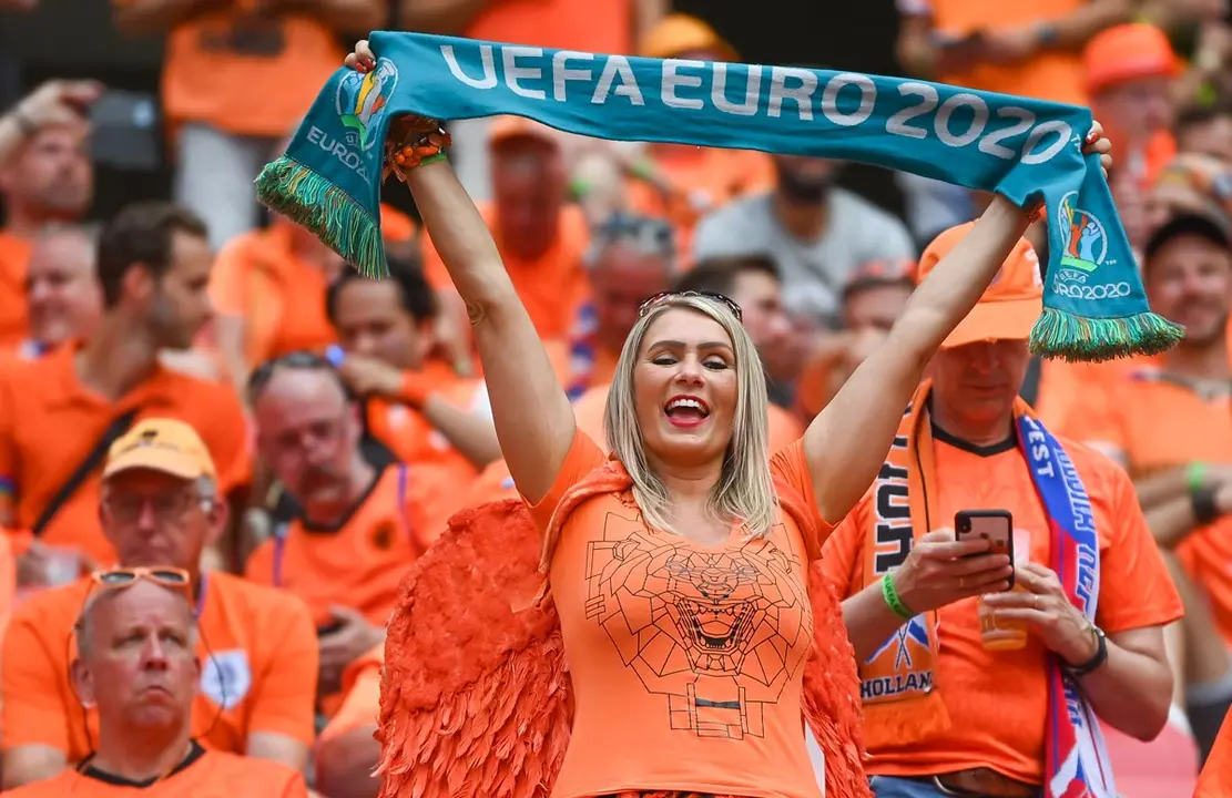 27 June 2021, Hungary, Budapest: Dutch fans cheer in the stands ahead of the UEFA EURO 2020 round of 16 soccer match between Netherlands and the Czech Republic at the Puskas Arena. Photo: Robert Michael/dpa-Zentralbild/dpa