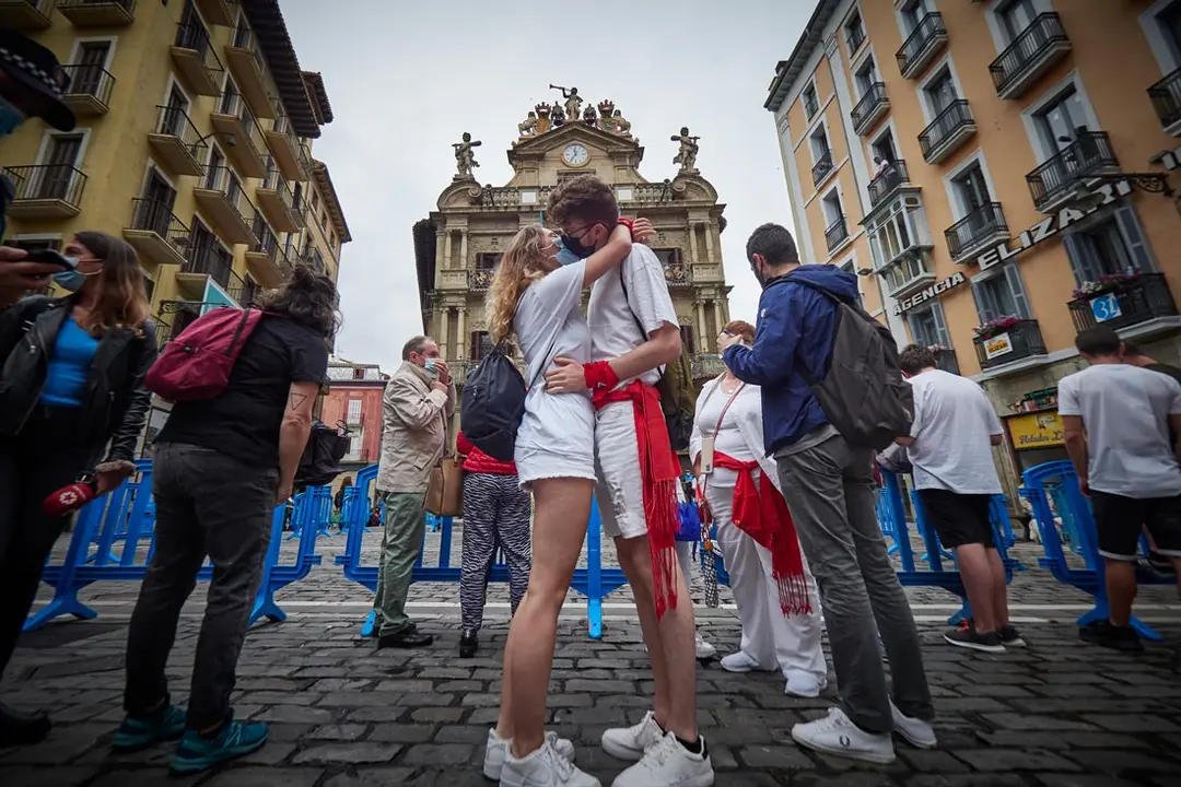 06 July 2021, Spain, Pamplona: A young couple kiss in front of the town hall, where the firing of "Chupinazo" rocket would usually take place to start the San Fermin festival. The San Fermin festival is cancelled again this year due to the Coronavirus pandemic. Photo: Eduardo Sanz/EUROPA PRESS/dpa