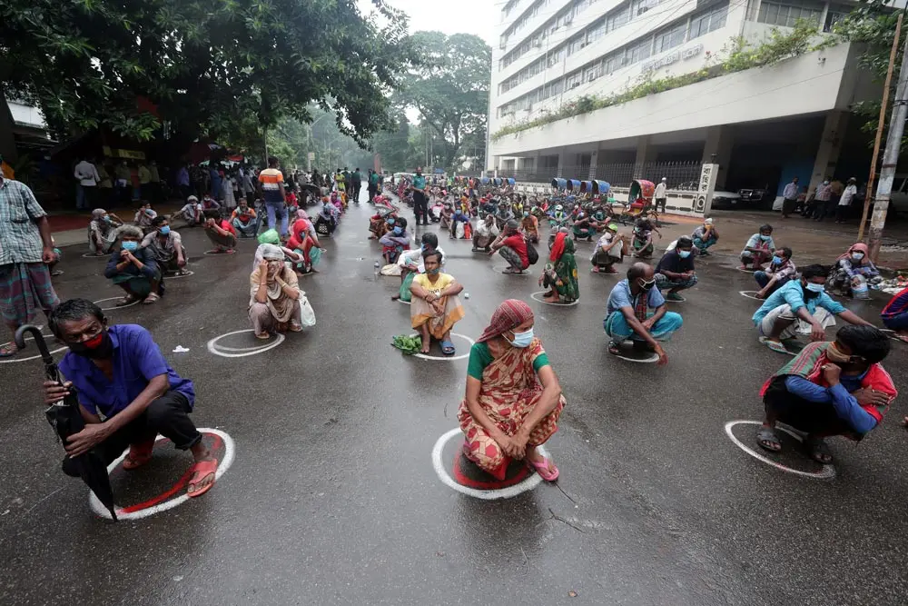 07 July 2021, Bangladesh, Dhaka: People and children wait on the road for free food during the new strict lockdown imposed to curb the spread of Covid-19 coronavirus in Dhaka. Photo: Habibur Rahman/ZUMA Wire/dpa