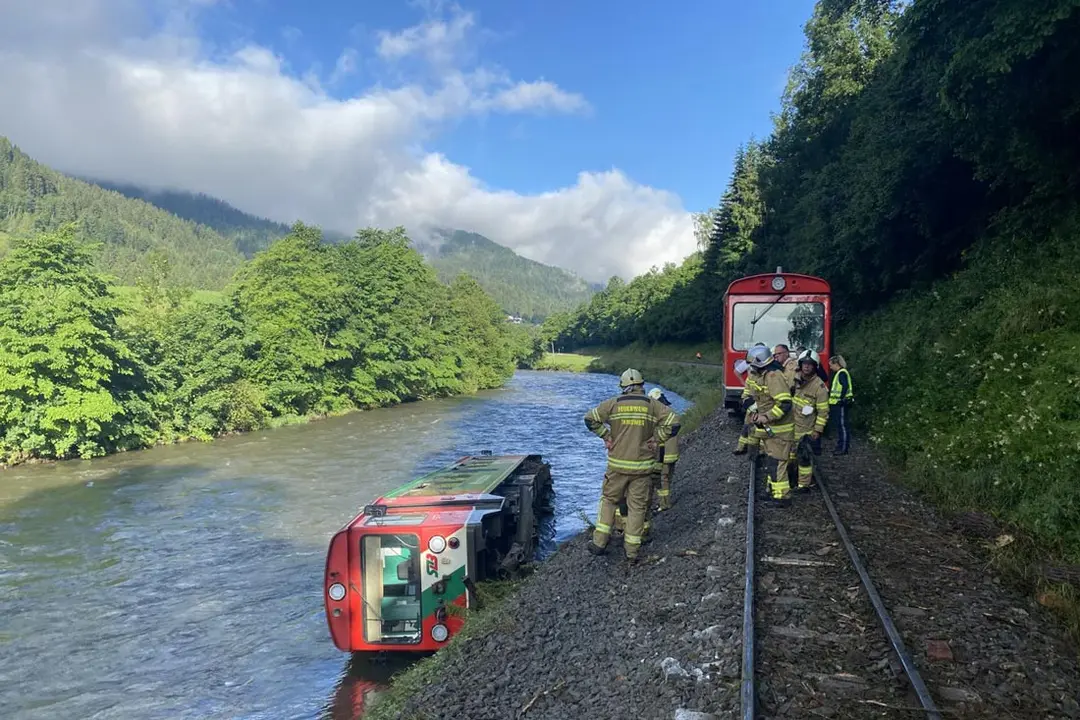 FILED - 09 July 2021, Austria, Ramingstein: A carriage of a regional train lies in the Mur River after a train with dozens of children and teenagers on board derailed in Austria and plunged into a river. Photo: Freiwillige Feuerwehr Tamsweg via APA/dpa