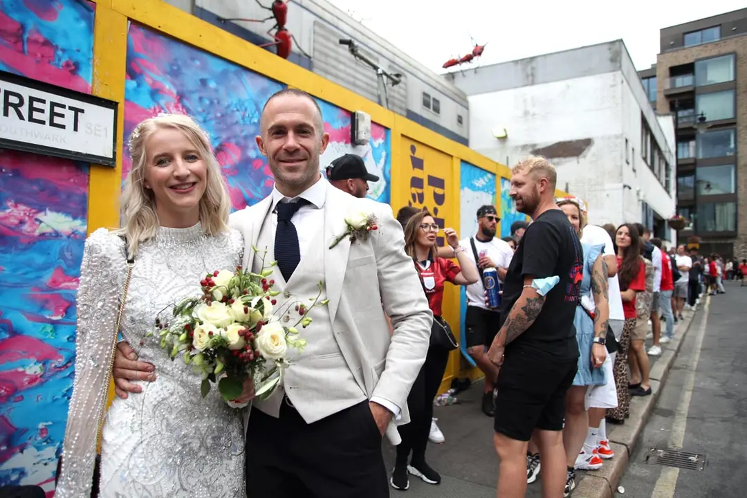11 July 2021, United Kingdom, London: Mike and Kitty McGonigle from Forest Hill in the south-east of London, who married today in Richmond, are now in the queue at the Vinegar Yard to watch the UEFA EURO 2020 final soccer match between Italy and England. Photo: Kieran Cleeves/PA Wire/dpa