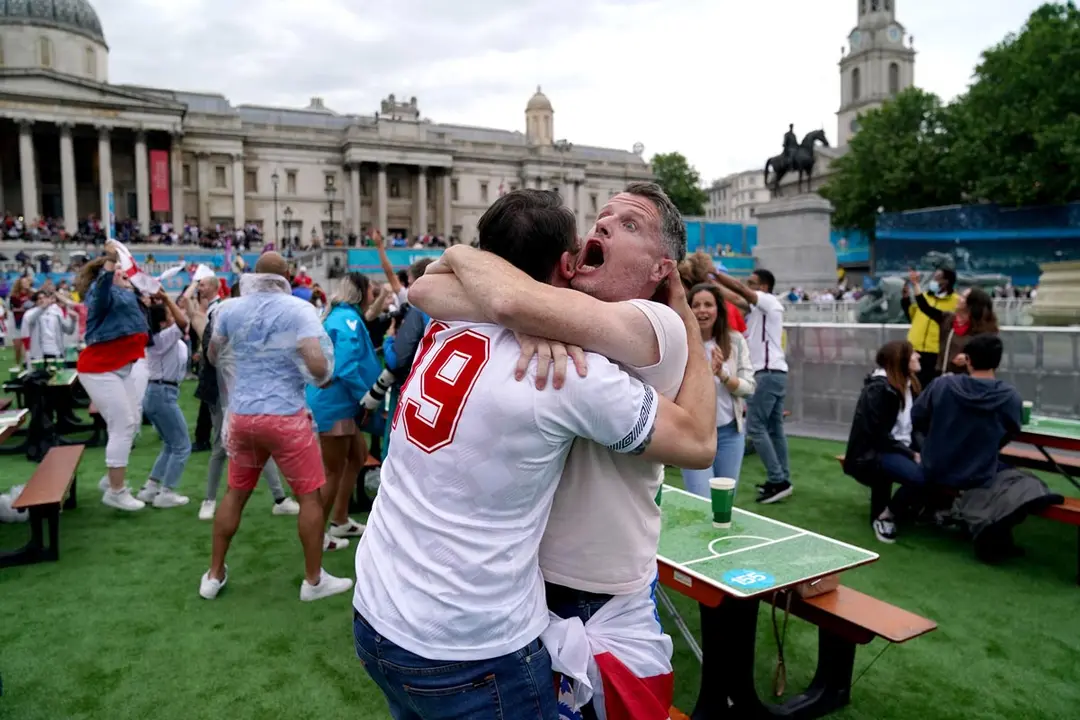 11 July 2021, United Kingdom, London: England fans celebrate at fan zone in the Trafalgar Square after England's Luke Shaw scored the opening goal during UEFA EURO 2020 final soccer match between Italy and England. Photo: Andrew Matthews/PA Wire/dpa