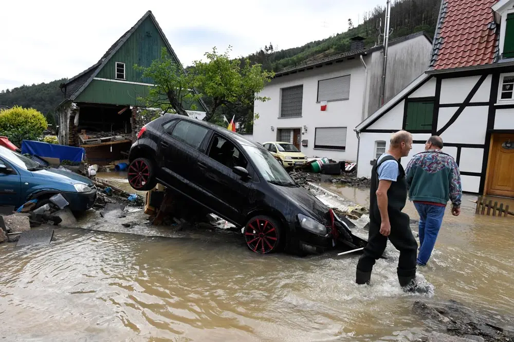 15 July 2021, North Rhine-Westphalia, Hagen: Residents look at the damage caused by the flooding of the Nahma river. Due to the heavy rainfall the small river had become a raging torrent. Photo: Roberto Pfeil/dpa