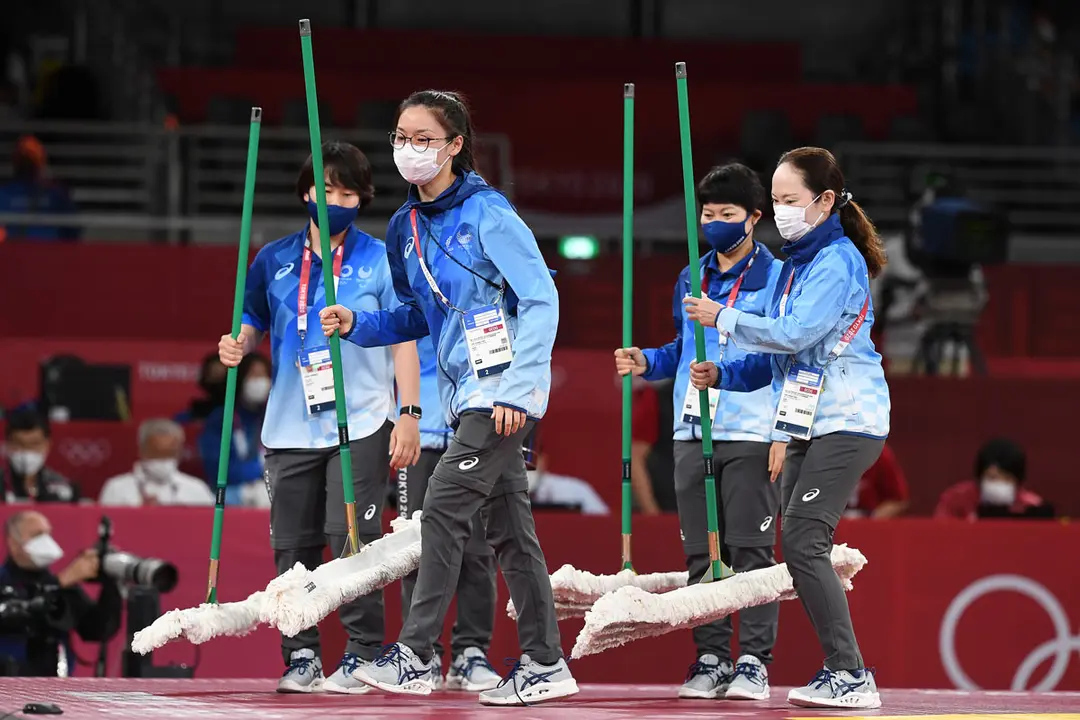 27 July 2021, Japan, Chiba: Helpers wipe the fight mat during the taekwondo women's +67kg round of 16 bouts, at Makuhari Messe Hall, during the Tokyo 2020 Olympic Games. Photo: Swen Pförtner/dpa