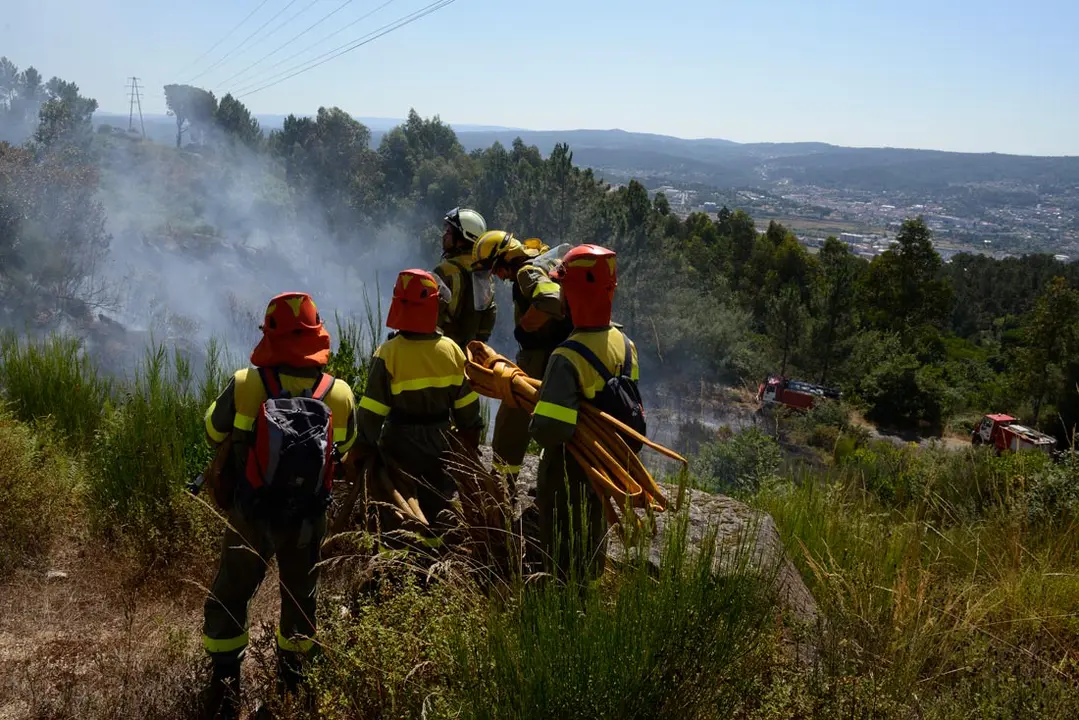 28 July 2021, Spain, Santa Marina do Monte: A group of firefighters consults during an operation to extinguish a forest fire in the municipality of Santa Marina do Monte. Photo: Rosa Veiga/EUROPA PRESS/dpa