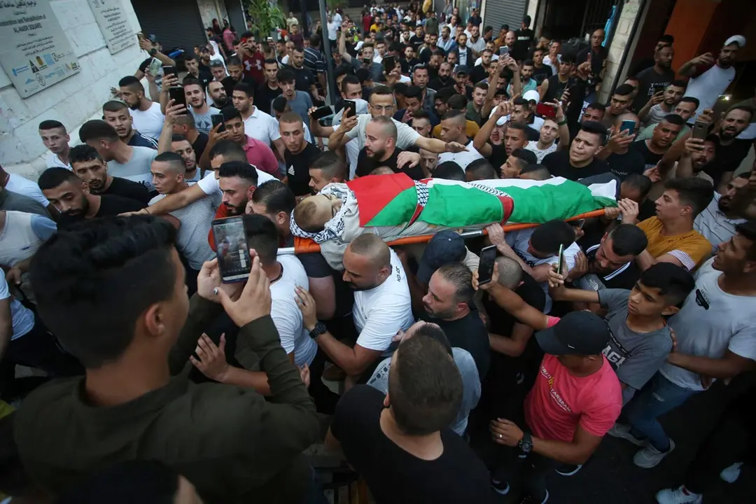 11 August 2021, Palestinian Territories, Nablus: Palestinian mourners carry the body of Deyaa Sabarini, who reportedly died of his wounds sustained during clashes with Israeli forces last week. Photo: Shadi Jarar'ah/APA Images via ZUMA Press Wire/dpa