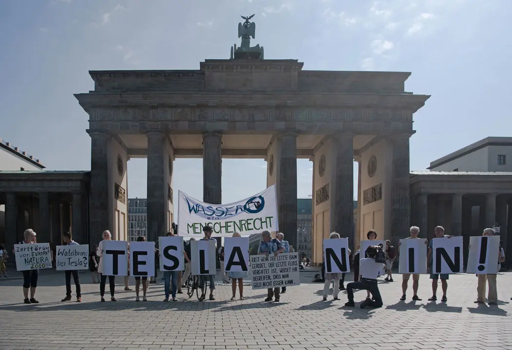 13 August 2021, Berlin: People protest against the construction of the Tesla factory in front of the Brandenburg Gate. Photo: Paul Zinken/dpa