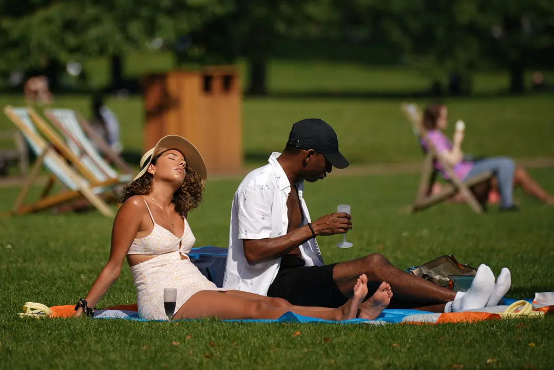 05 September 2021, United Kingdom, London: A couple relax on the grass of St James's Park amid warm weather conditions. Photo: Yui Mok/PA Wire/dpa