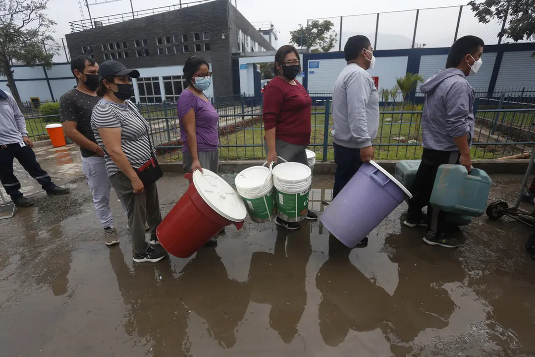 06 September 2021, Peru, San Juan de Lurigancho: People line up holding large buckets to get water after a water outage due to a burst pipe. The Potable Water and Sewerage Service of Lima (Sedapal) announced that the water supply will be restored in San Juan de Lurigancho in the next seven days. Photo: Gian Masko/dpa
