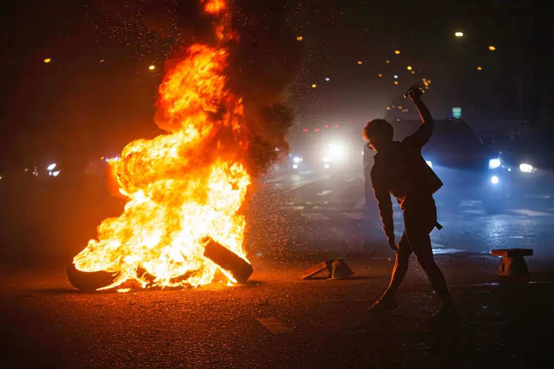 12 September 2021, Thailand, Bangkok: A protester burns tires and wood during a protest at Din Daeng intersection, demanding the resignation of Thailand Prime Minister Prayut Chan-O-Cha. Photo: Varuth Pongsapipatt/SOPA Images via ZUMA Press Wire/dpa
