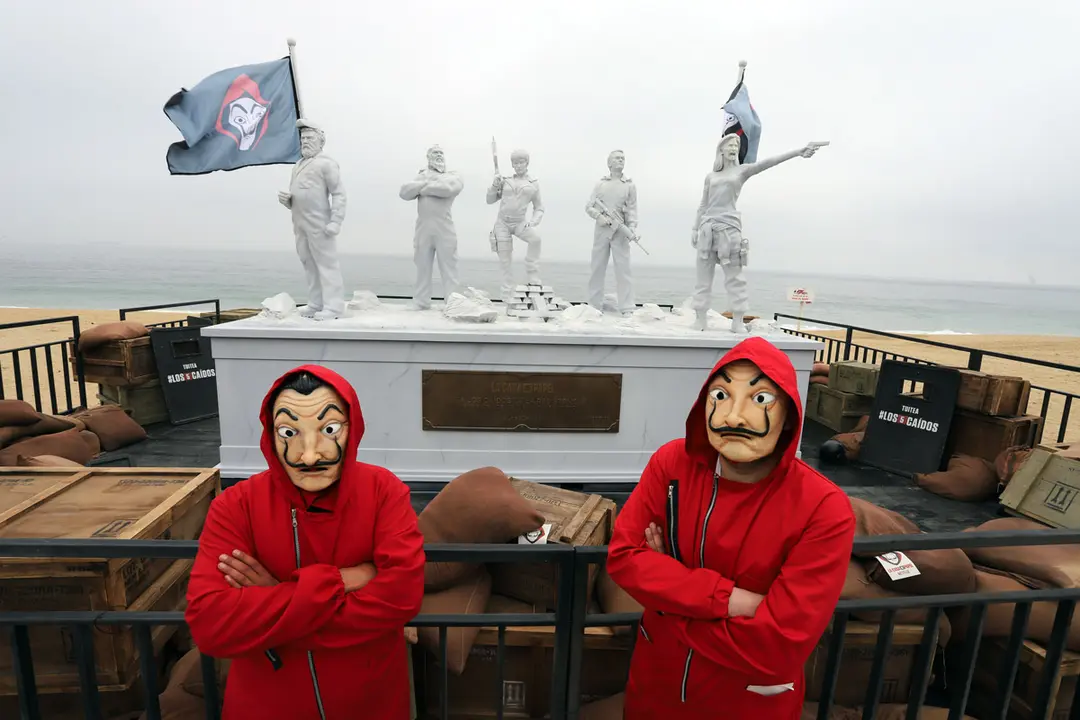 16 September 2021, Chile, Vina Del Mar: Two people wearing costumes from Spanish TV series "La casa de papel" pose in front of a statue sculpted for the characters of the Netflix show. Photo: Manuel Lema Olguin/Agencia Uno/dpa