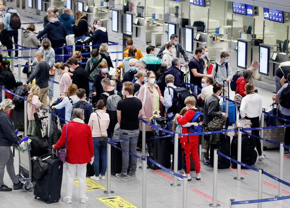 09 October 2021, North Rhine-Westphalia, Duesseldorf: Travellers wait for their check-in at Duesseldorf International Airport. The autumn holidays have begun in North Rhine-Westphalia. Photo: Roland Weihrauch/dpa