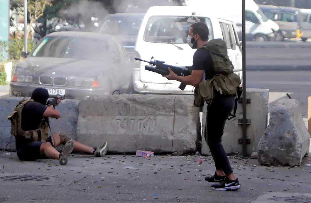 14 October 2021, Lebanon, Beirut: Gunmen take position during clashes in the area of Tayouneh, after gunfire erupted at a protest by supporters of the Shiite Hezbollah movement against the judge investigating the city's port blast, near the former civil war front-line between Muslim Shiite and Christian areas. At least six people were killed and 32 injured in Beirut. Photo: Haitham Moussawi/APA Images via ZUMA Press Wire/dpa.