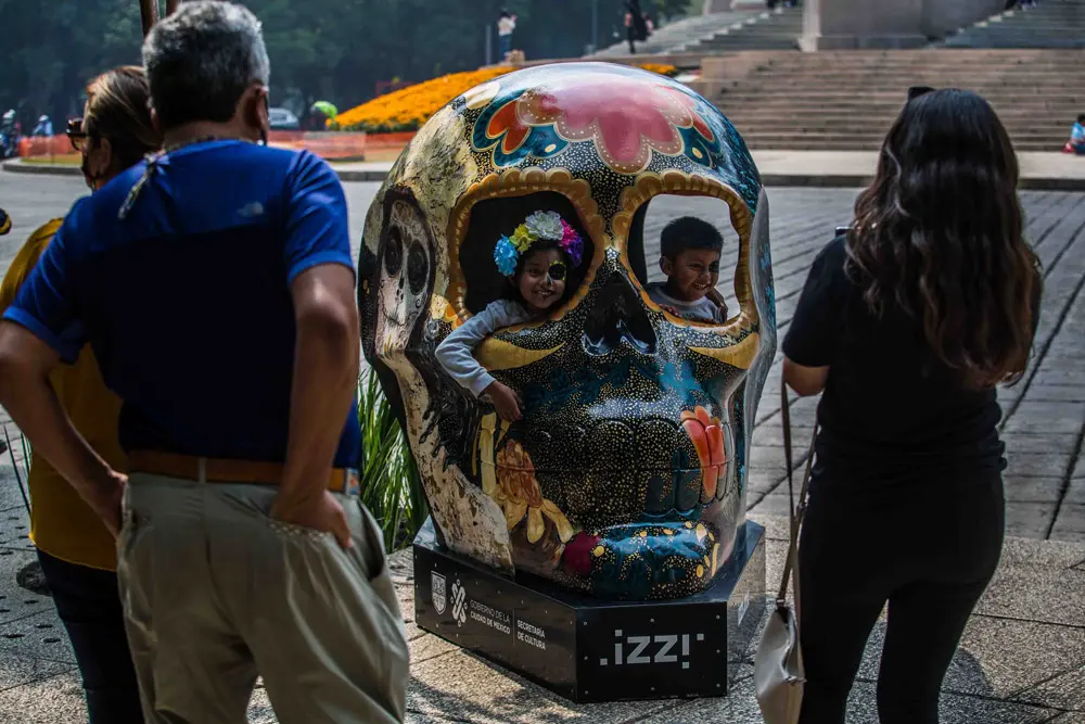 29 October 2021, Mexico, Mexico City: Children sit inside a giant skull displayed at the exhibition Mexicraneos in Paseo de la Reforma Avenue in Mexico City, ahead of the Day of the Dead, a holiday celebrated in Mexico on the 01 and 02 November. Photo: -/El Universal via ZUMA Press Wire/dpa
