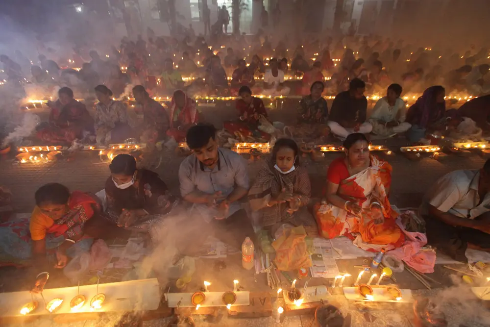 06 November 2021, Bangladesh, Dhaka: Hindu devotees pray in front of Shri Shri Lokanath Brahmachari Ashram temple during the religious festival Rakher Upobash, also known as Kartik Brati, to save their family and dears from cholera and pox disease. Photo: Habibur Rahman/ZUMA Press Wire Service/dpa.