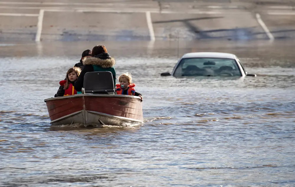 16 November 2021, Canada, Abbotsford: A woman with children who were stranded by high water due to flooding are rescued by a volunteer operating a boat. Photo: Darryl Dyck/The Canadian Press via ZUMA/dpa.