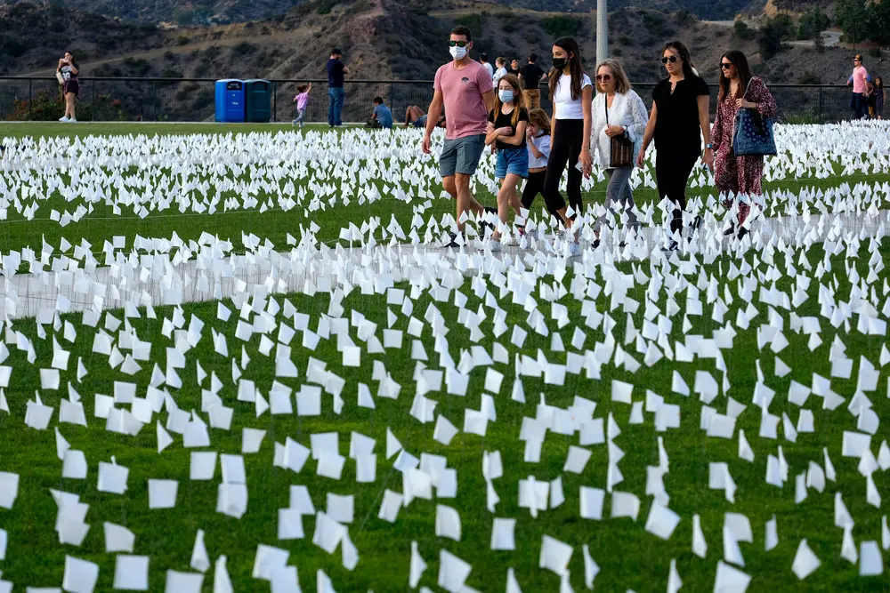 22 November 2021, US, Los Angeles: People visit the COVID-19 memorial "Strength and Love" made of 26,661 white flags on the lawn of the Griffith Observatory in Los Angeles. Each flag represents a life lost to COVID-19 in Los Angeles County. Photo: Ringo Chiu/ZUMA Press Wire/dpa.