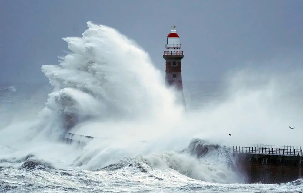 27 November 2021, United Kingdom, Sunderland: Huge waves crash against the sea wall and Roker Lighthouse in Sunderland in the tail end of Storm Arwen. Photo: Owen Humphreys/PA Wire/dpa.