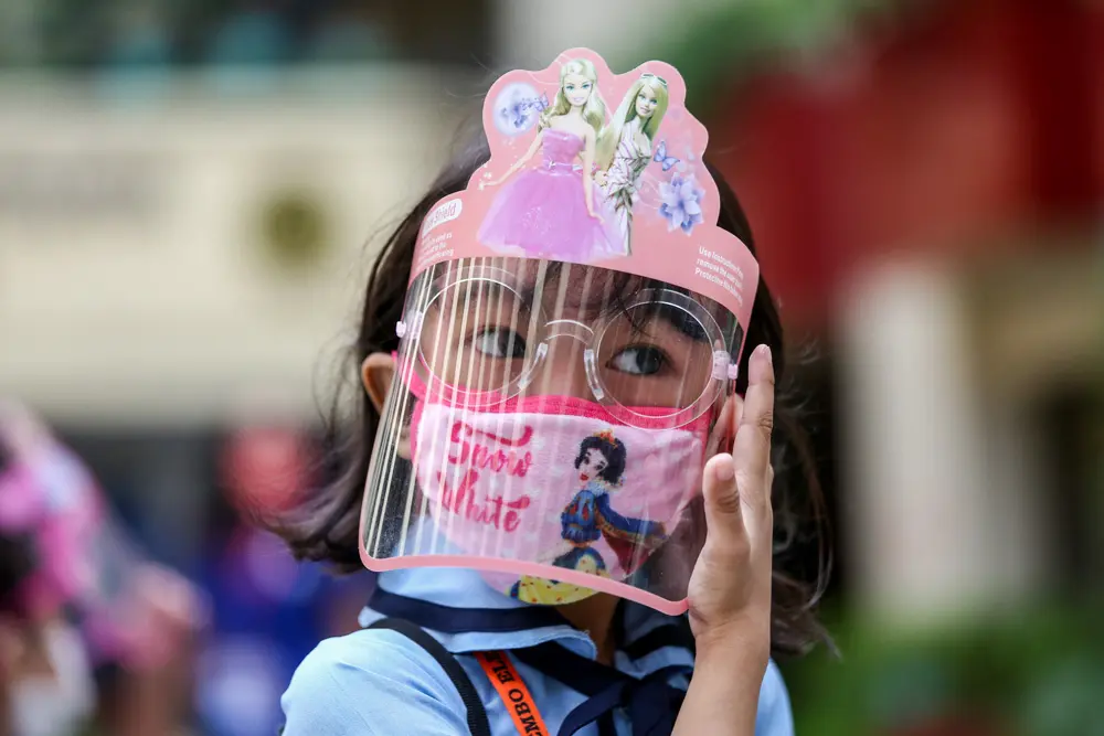 06 December 2021, Philippines, Makati City: A students fixes her face shield before attending an in-person class at an elementary school. Around 28 schools in the Philippine capital began conducting limited face-to-face classes with strict health protocols to prevent the spread of COVID-19. Photo: Basilio Sepe/ZUMA Press Wire/dpa.