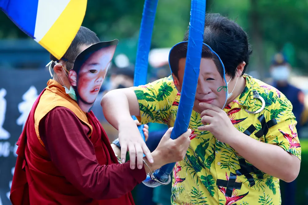10 December 2021, Taiwan, Taipei City: A demonstrator wearing a mask with the face of Chinese President Xi Jinping handcuffs a monk, during a protest calling to boycott the Beijing Winter Games 2022, outside the Bank of China, following several diplomatic boycotts of the Games. Photo: Daniel Ceng Shou-Yi/ZUMA Press Wire/dpa.