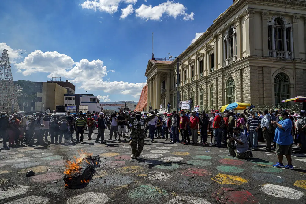 12 December 2021, El Salvador, San Salvador: Protesters burn a box with images of Salvadoran President Nayib Bukele and Bitcoin signs during an anti-government protest. Photo: Camilo Freedman/SOPA Images via ZUMA Press Wire/dpa.