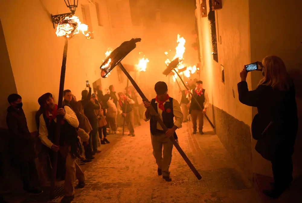 FILED - 13 December 2021, Spain, Malaga: Villagers hold baskets of burning wicks soaked in oil during the folk festival of "Los Rondeles" on the eve of the feast of Saint Lucia in the small village of Casarabonela. Photo: Jesus Merida/SOPA Images via ZUMA Press Wire/dpa.