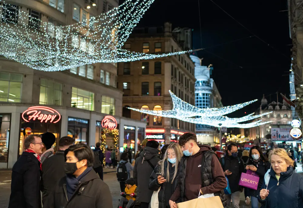 21 December 2021, United Kingdom, London: People at a Christmas market in Leicester Square, as the government today ruled out introducing further restrictions in England ahead of Christmas to slow the spread of the Omicron variant of coronavirus. Photo: Dominic Lipinski/PA Wire/dpa.