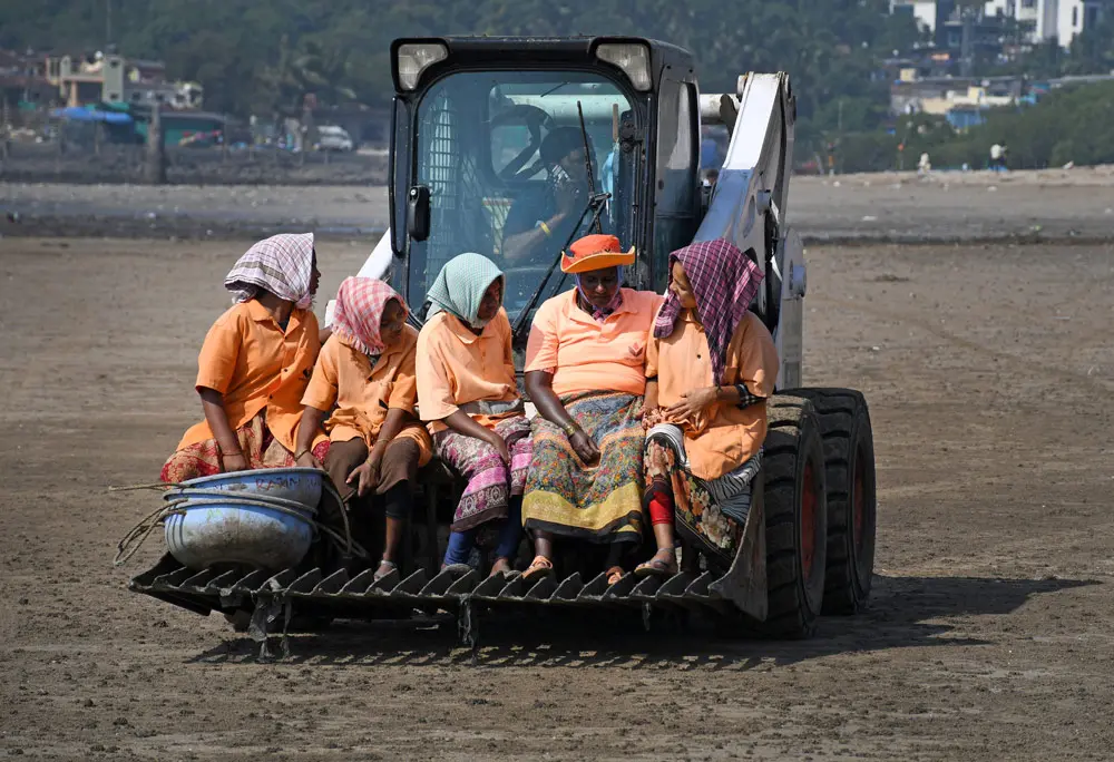29 December 2021, India, Mumbai: Women marshals riding on a beach clean up vehicle at Versova beach. Photo: Ashish Vaishnav/SOPA Images via ZUMA Press Wire/dpa.