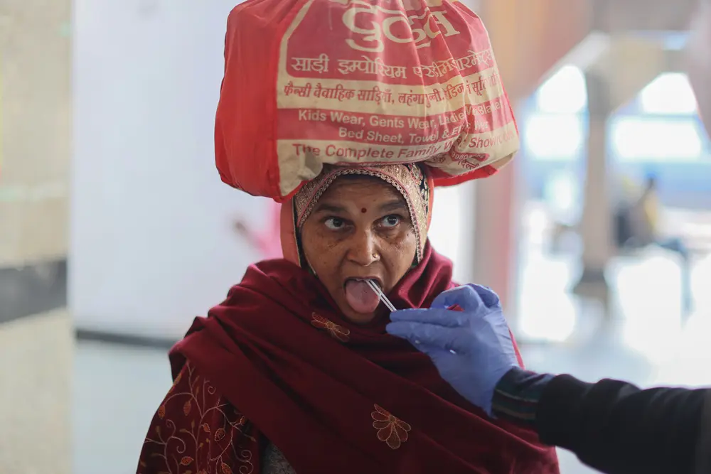01 January 2022, India, New Delhi: A healthcare worker collects a coronavirus (Covid-19) test swab sample from a woman amidst the spread of the disease, at a railway station. Photo: Karma Sonam Bhutia/ZUMA Press Wire/dpa.