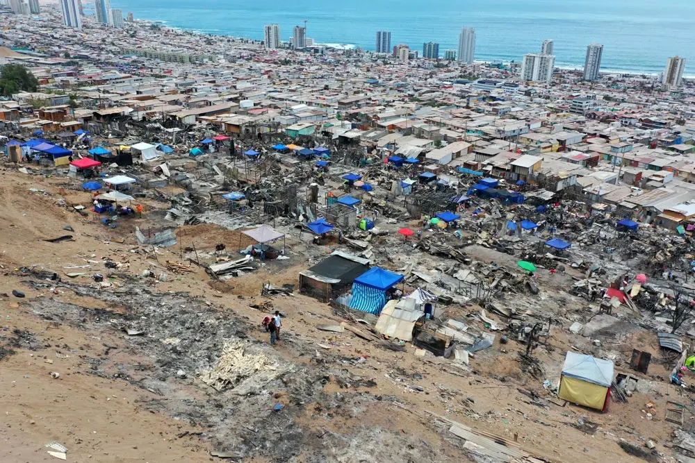 12 January 2022, Chile, Iquique: People whose houses were destroyed in a fire in the Laguna Verde settlement are camping on the site to prevent the properties from being occupied by other people. At least 100 houses had been destroyed in the major fire on January 11. Photo: Cristian Vivero Boornes/Agencia Uno/dpa.