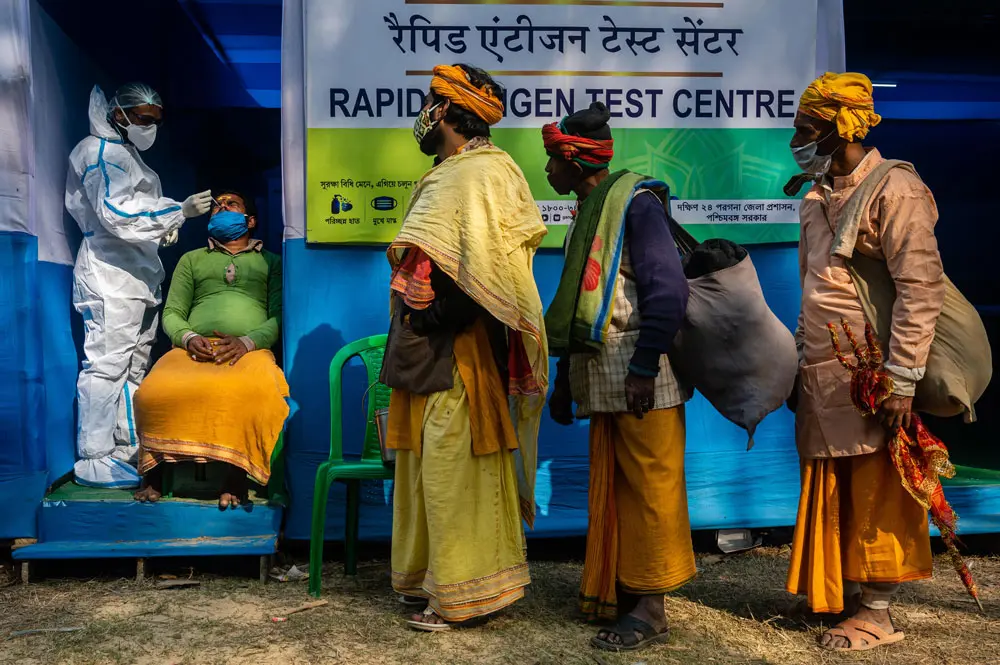 08 January 2022, India, Kolkata: A group of Sadhus stand in a queue for a Covid-19 rapid antigen test at a base camp for the devotees heading towards Gangasagar Mela. Photo: Sankhadeep Banerjee/ZUMA Press Wire/dpa.