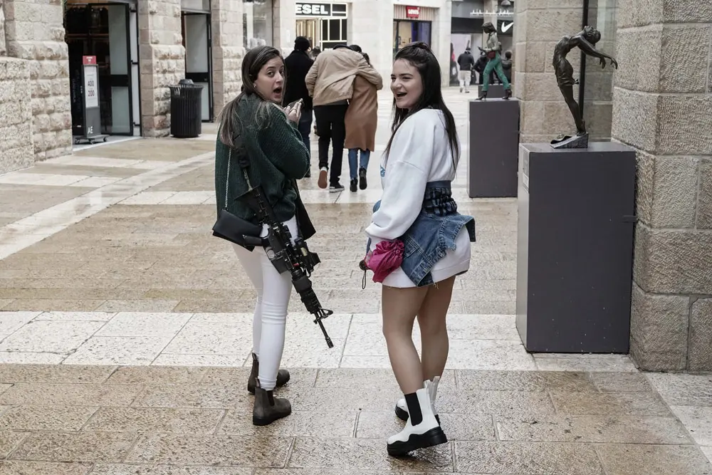 24 December 2021, ---, Jerusalem: An off duty IDF soldier strolls through the Alrov Mamilla Shopping Mall, carrying an M16 assault rifle. Photo: Nir Alon/ZUMA Press Wire/dpa.