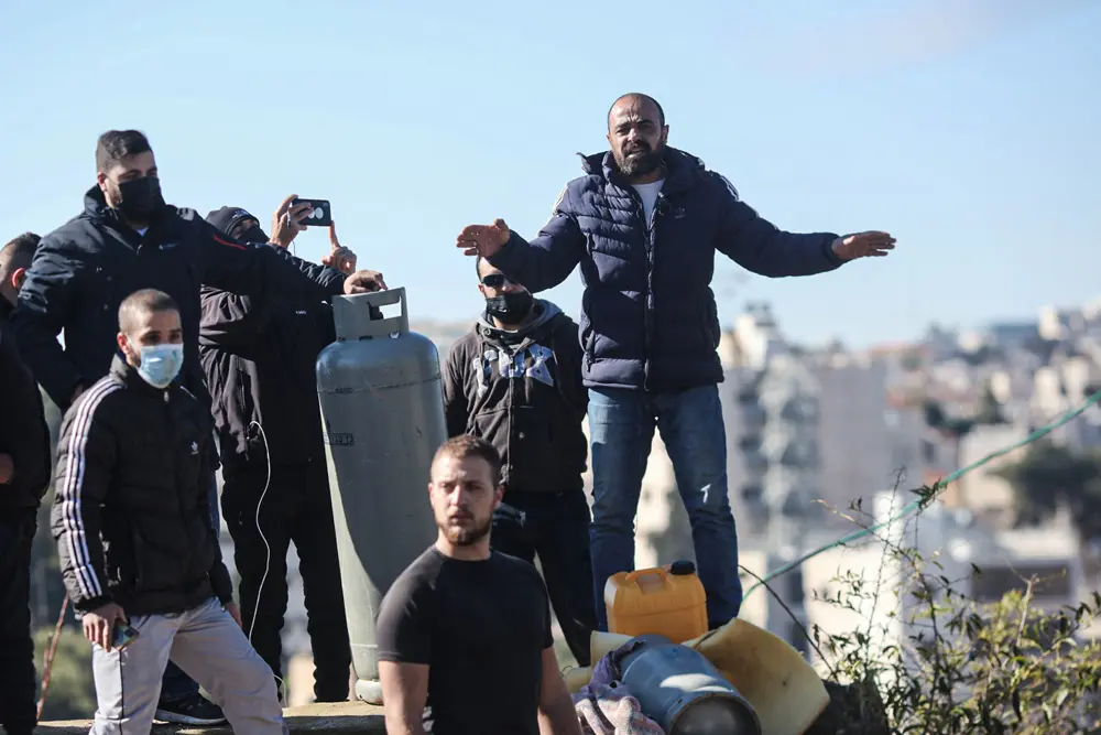 17 January 2022, Israel, Jerusalem: Members of a Palestinian family stand on the roof of their home and threatening to set off a gas tank as Israeli police prepare to evict the house in the East Jerusalem neighborhood of Sheikh Jarrah. The Jerusalem Municipality has expropriated the land on which the family home is built in order to build a school. Photo: Ilia Yefimovich/dpa