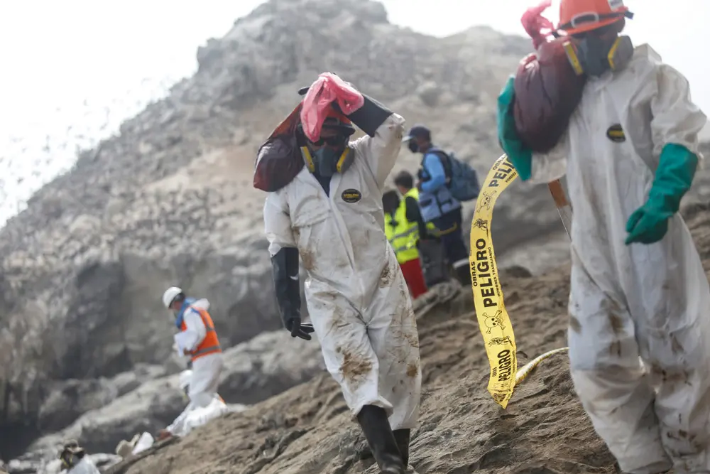 FILED - 27 January 2022, Peru, Ventanilla: Units work to clean up the oil spill at Cavero beach after about 6,000 barrels (159 liters each) of oil spilled during the unloading of a tanker at the La Pampilla refinery owned by Spanish energy company Repsol. Photo: Gian Masko/dpa.
