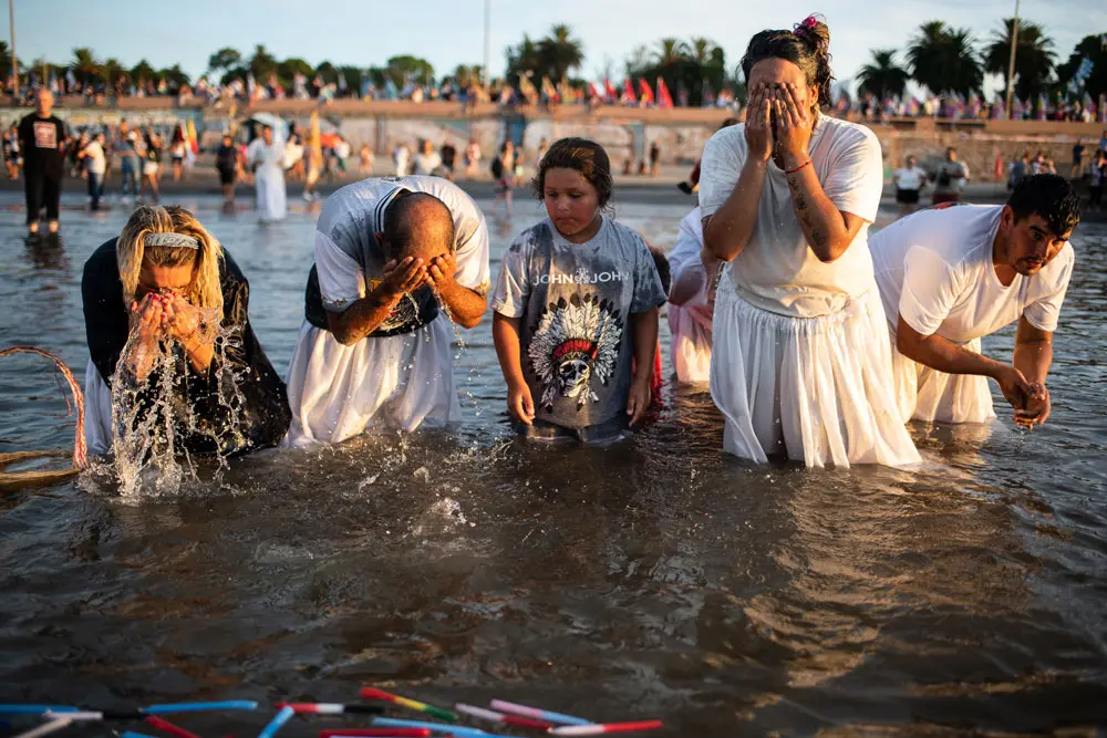 02 February 2022, Uruguay, Montevideo: Followers of the Umbanda Afro-American take part in a ritual offering tribute to Yemanja, the African goddess of the sea. Devotees traditionally mark the day dressed in white while carrying a statue of Yemanja to the beach, along with lighting candles and tossing flowers and other offerings into the sea. Photo: Santiago Mazzarovich/dpa.