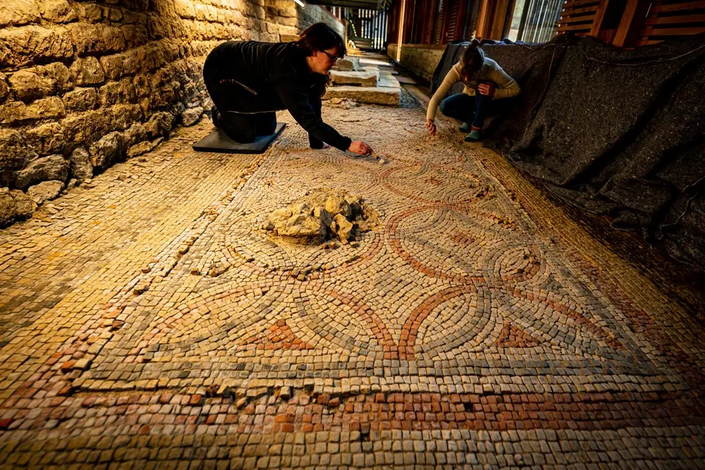 16 February 2022, United Kingdom, Yarnworth: National Trust conservators clean the Corridor Mosaic - one of the longest in-situ mosaics in the country - using sponges, brushes and cotton wool to remove the naturally occurring salt deposits and restore the 4th-century tiles at the Chedworth Roman Villa in Yarnworth, Gloucestershire. Photo: Ben Birchall/PA Wire/dpa.