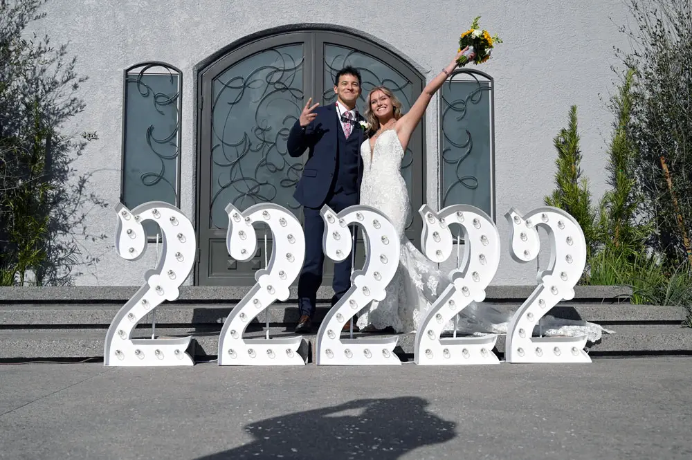 22 February 2022, US, Las Vegas: Aron and Rachel San Juan pose for a photo with a 2/22/22 sign at the Chapel of the Flowers wedding chapel in Las Vegas. The venue's two locations had 200 weddings scheduled for the palindrome date when otherwise a normal busy day would include 50 ceremonies. Photo: David Becker/ZUMA Press Wire/dpa.